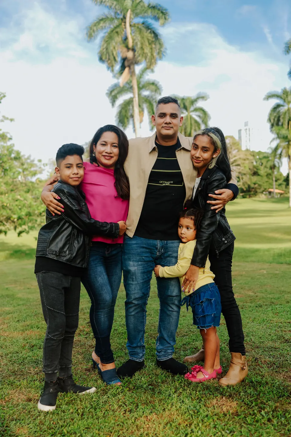 Una familia de cinco comparte un momento al aire libre.